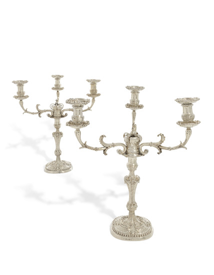 A PAIR OF GEORGE III SILVER THREE-LIGHT CANDELABRA, LONDON, THE CANDLESTICKS WITH MARK OF JOHN MEWBURN, 1811, THE CANDELABRA BRANCH SOCKETS AND NOZZLES WITH MAKER'S MARK TD, PROBABLY FOR THOMAS DANIELL, LONDON, 1807