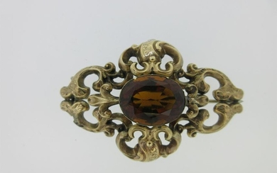 A Victorian citrine brooch in an ornate mount