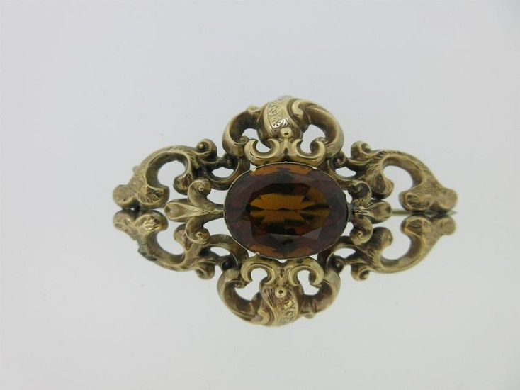 A Victorian citrine brooch in an ornate mount