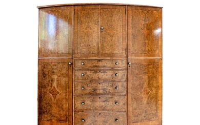 A burr walnut and crossbanded bow front wardrobe. The centra...