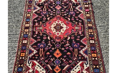 A deep ground full pile hand woven Persian Red village Rug w...