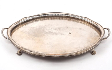 A large twin-handled tray with pierced sides, of oval form with shaped sides and four lion paw feet, 69.7cm long
