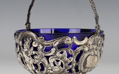 A late Victorian silver bonbon basket with swing handle, the sides pierced and embossed with cherubs