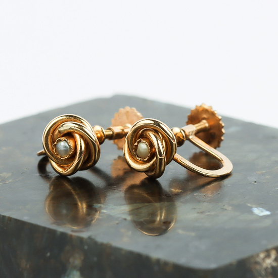 A pair of earrings, 18k gold, in the form of a knot with a pearl.