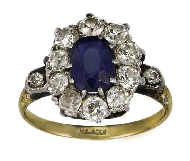 A sapphire and diamond cluster ring, the single oval-cut sapphire with old-brilliant-cut diamond surround, to a plain hoop, ring size H