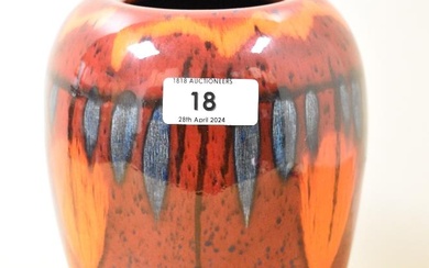 A vintage Poole Pottery vase, having red, orange and blue glaze.
