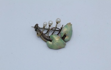 An Art Nouveau enamelled leaf brooch, featuring prongs terminated by...