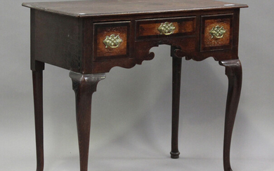An early 18th century oak lowboy, the mahogany banded top above three drawers, on cabriole legs and