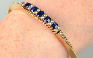 An early 20th century 18ct gold sapphire and split pearl hinged bangle.