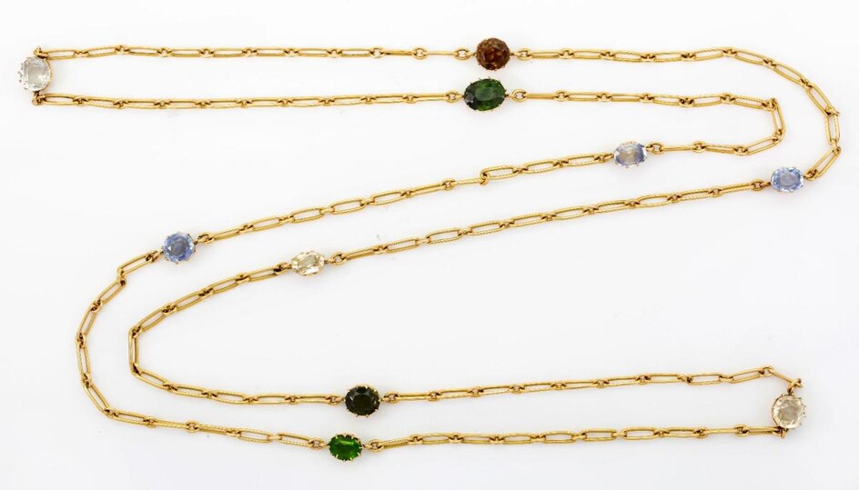 An early 20th century gold multi- gem-set guard chain, of fetter-link design with claw-set gem intervals, gems include sapphire, green tourmaline, zircon, quartz and one green paste, c. 1910, length 100cm