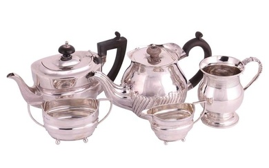 An early 20th-century three-piece silver tea set, the teapot with a wooden handle and finial-topped