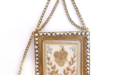FRIENDSHIP SOUVENIR D'AMITIE in 18k gold and padlocked eglomised glass holding dried flowers and a drawing of a woman is his dog. It is surrounded by a white pearl frame (untested). Dimensions: 3.5 x 4.5 cm. Gross weight : 19.40 gr. A gold, pearl and...