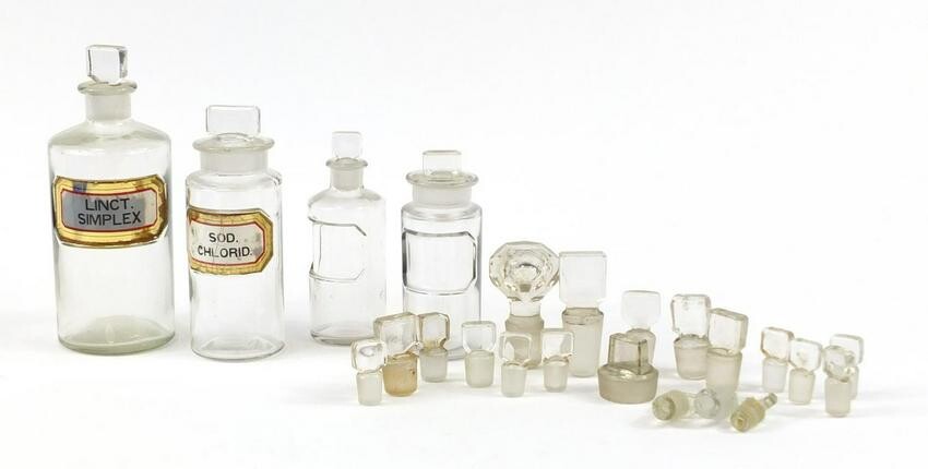 Four antique glass apothecary jars and extra stoppers