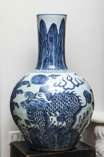 Importante paire de vases à panse globulaire et haut col en porcelaine blanche décoré en bleu cobalt sous couvert de Kilins dans un jardin arboré de bananier