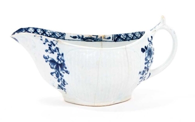 Lowestoft sauceboat, of early form with basketweave panels to the sides, blue floral sprays flanking the spout and handle, a half flowerhead and diaper border inside the rim, 15.3cm long