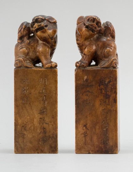 PAIR OF CHINESE RED-BROWN SOAPSTONE SEALS Both tops with lions. Bases cut with calligraphy. Heights 6.25".
