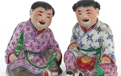 Pair of Chinese porcelain figures of children wearing robes,...