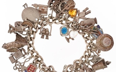 Silver charm bracelet with a large collection of mostly silv...