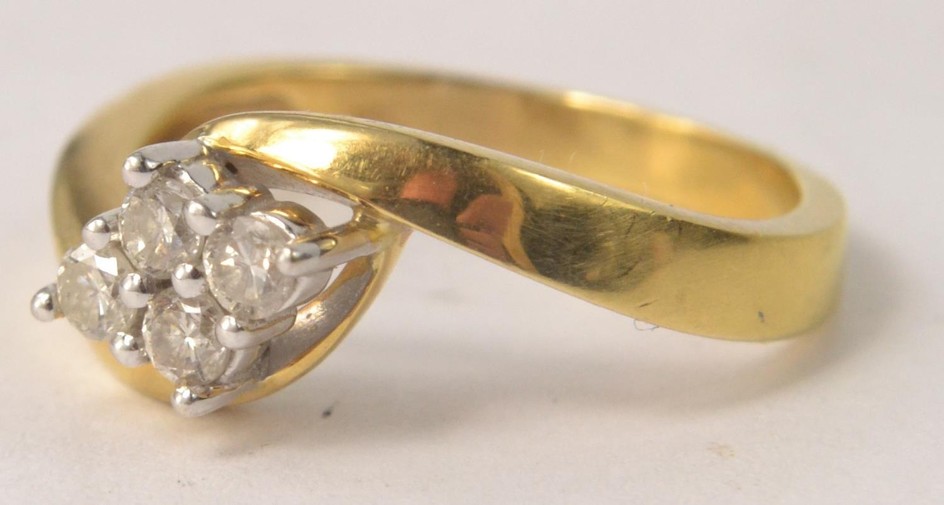 Stamped 18k gold ring with 4 small diamonds set in a diamond...