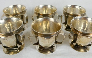 Sterling Silver Arts and Crafts set of six three handled egg cups. Weight 292 grammes. Hallmarked Chester 1907 - makers Nathan and Hayes. Height 4.5cm - Diam 4.8cm.