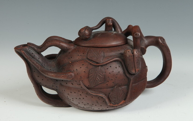 TWO CHINESE BROWN POTTERY YIXING TEAPOTS. First, fully sculpted leaf...
