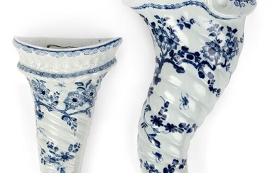 Two Worcester porcelain blue and white wall pockets, c.1755-65, blue crossed swords mark to the larger example, each of spiral-moulded cornucopia form, the smaller example with a moulded boss border, painted in blue with flowering prunus branches...