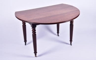 A Victorian mahogany drop leaf circular table on turned and fluted legs, terminating on brass castors, 110 cm diameter.