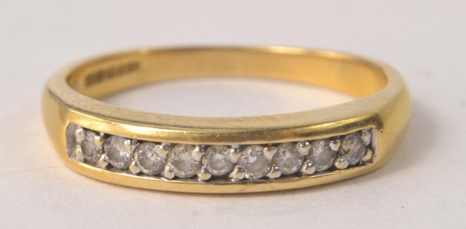750 stamped gold ring with a multi faceted diamond upper ba...