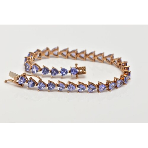 A 9CT GOLD TANZANITE LINE BRACELET, designed with thirty-thr...