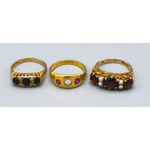 A 9ct. Gold Dress Ring set three garnets interspaced with pe...