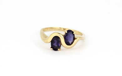 A 9ct yellow gold ring set with two oval cut sapphires, (Q.5).
