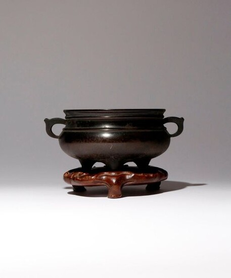 A CHINESE BRONZE TRIPOD INCENSE BURNER QING DYNASTY The compressed...