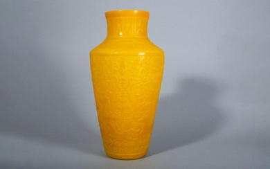 A CHINESE PEKING GLASS YELLOW 'LONGEVITY' VASE. The tapered body carved with real and mythical beasts and shou characters, cash and bats to the angular shoulder, the waisted neck and foot with bands of stylised leaves, 28cm H. 黃料福壽紋瓶