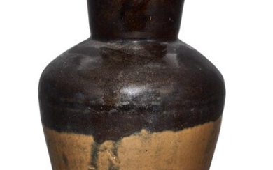 A Chinese stoneware brown-glazed vase, Ming dynasty, the top half covered in a thick dark brown glaze stopping mid way to a light brown tone, unglazed base, 32.5cm high 明 醬釉敞口瓶