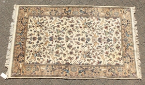 A GOOD INDIAN WOOL RUG with hunting scenes on a white