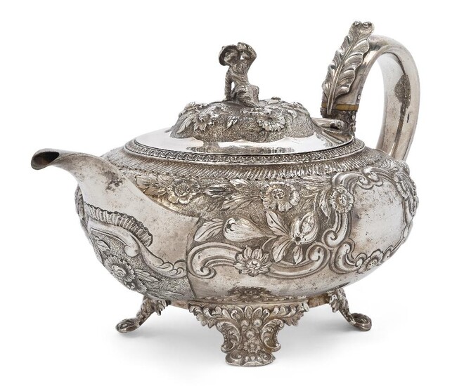A George IV silver teapot, London, 1824, Hyam Hyams, of compressed rounded form, the body repousse decorated with fruiting vines and scrolls and raised on four bracket feet, the hinged cover with figural finial to acanthus tipped handle with ivory...