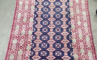 A HAND KNOTTED RUG