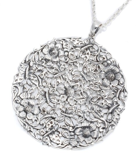A SILVER PENDANT ON CHAIN; 58.5mm pierced disc featuring floral motifs on a cable link chain, length 65cm.