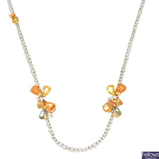 A brilliant-cut diamond line necklace, with vari-hue sapphire cluster highlights.