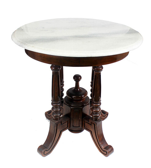 A carved teak round table with marble top