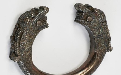 A cast metal alloy archaistic bangle