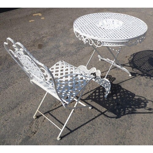 A circular metal garden table and chair; the table (78cm dia...