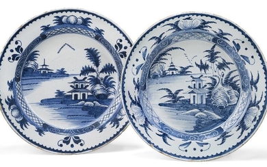 A near pair of English delft chargers, possibly Lambeth, 18th century, each decorated with chinoiserie scenes of pagodas each under a tree with fern-like foliage, surrounded by a border of trellis and graffito designs, the rim with three mounds...