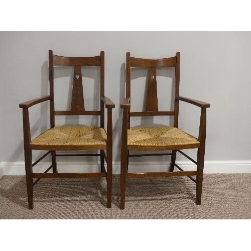 A pair of Arts and Crafts oak Carver Chairs, with rush seats...