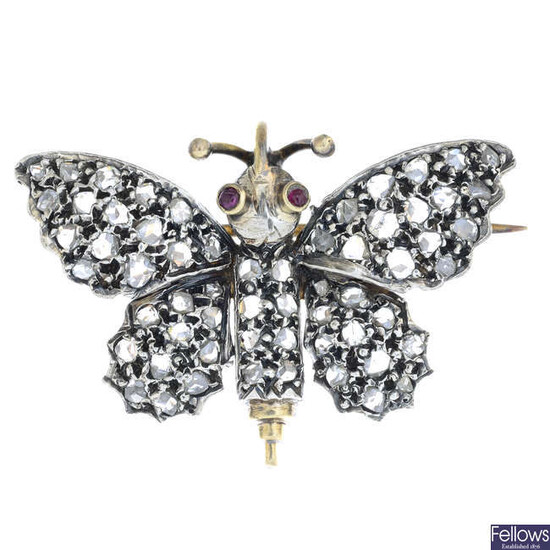 A rose-cut diamond butterfly brooch, with ruby eye detail.