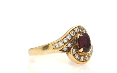 A ruby and diamond ring set with faceted ruby flanked by numerous...