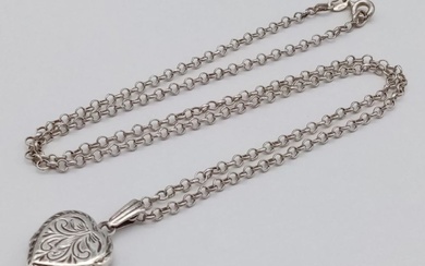 A vintage sterling silver heart locket pendant on...