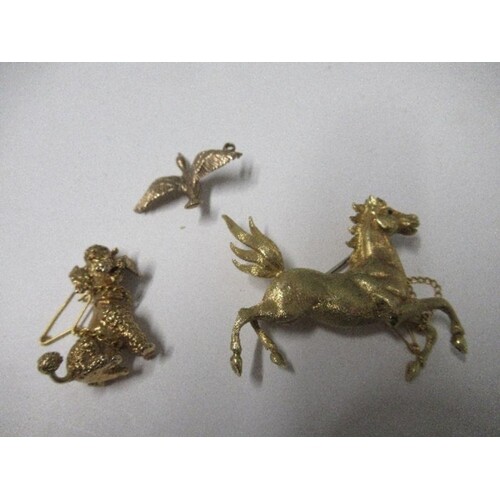 A yellow metal horse brooch, a 9ct gold duck pendant, and a ...