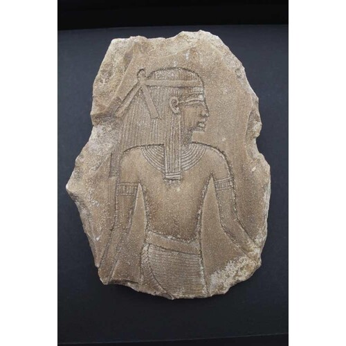 AN EGYPTIAN LIMESTONE FRAGMENT, relief carved with bust leng...