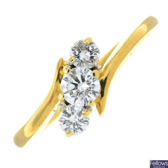 An 18ct gold brilliant-cut diamond three-stone crossover ring.